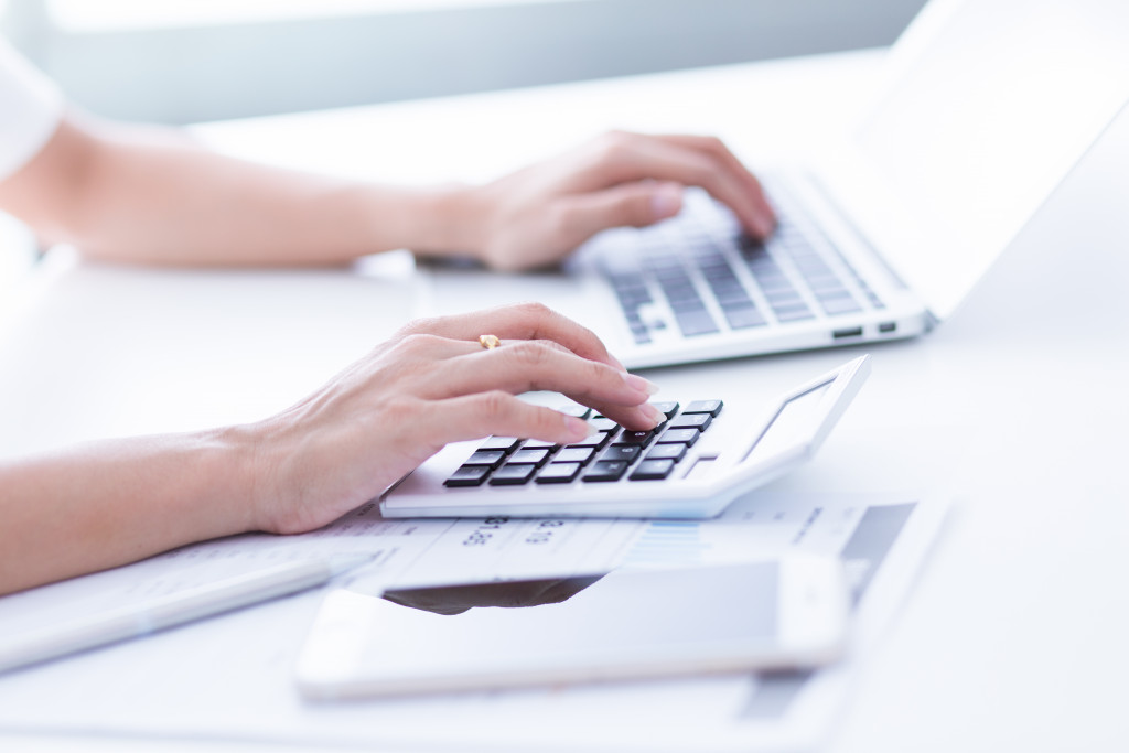 woman using laptop and calculator