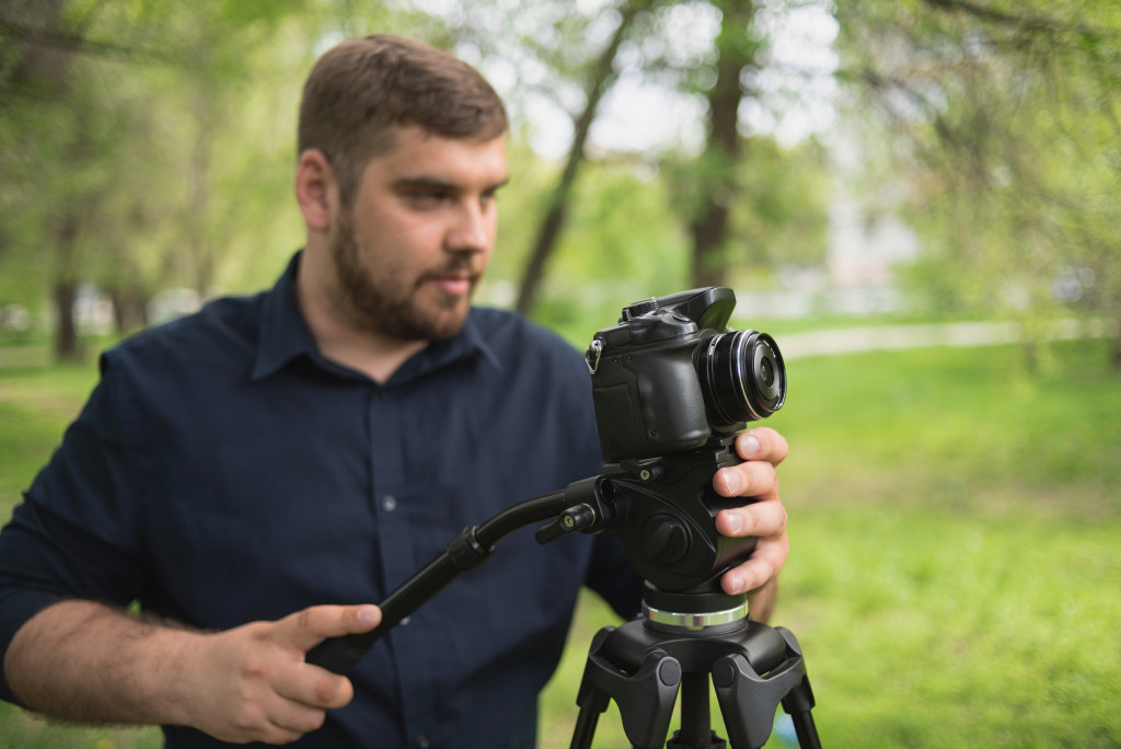 A man filming an event outdoor