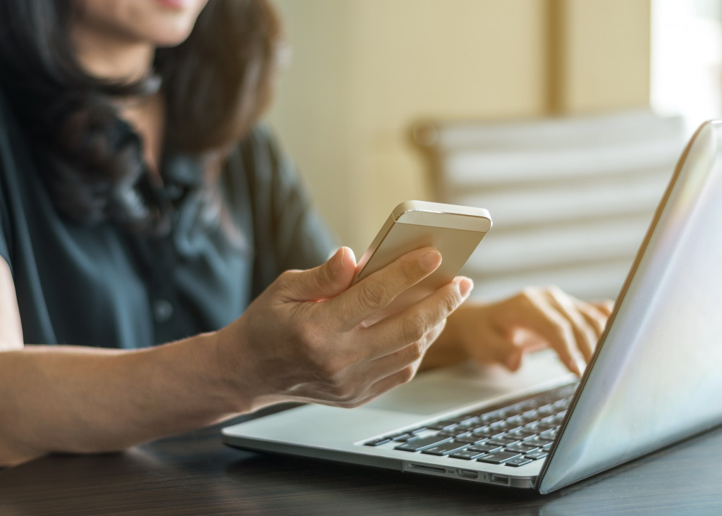 woman using laptop and phone 