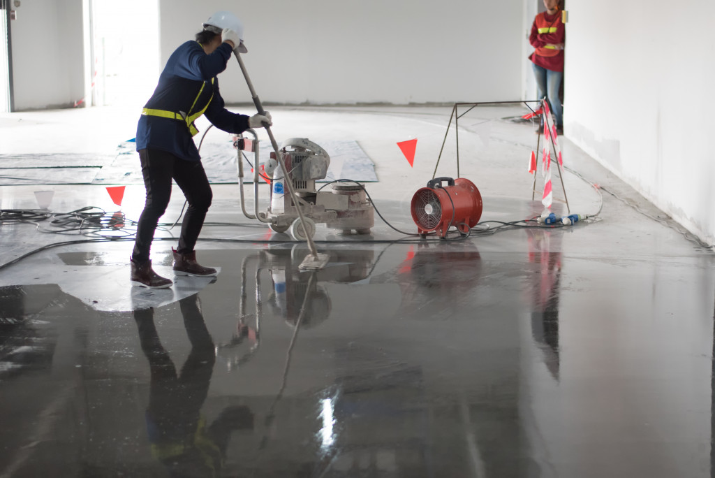 A worker applying coating on a floor