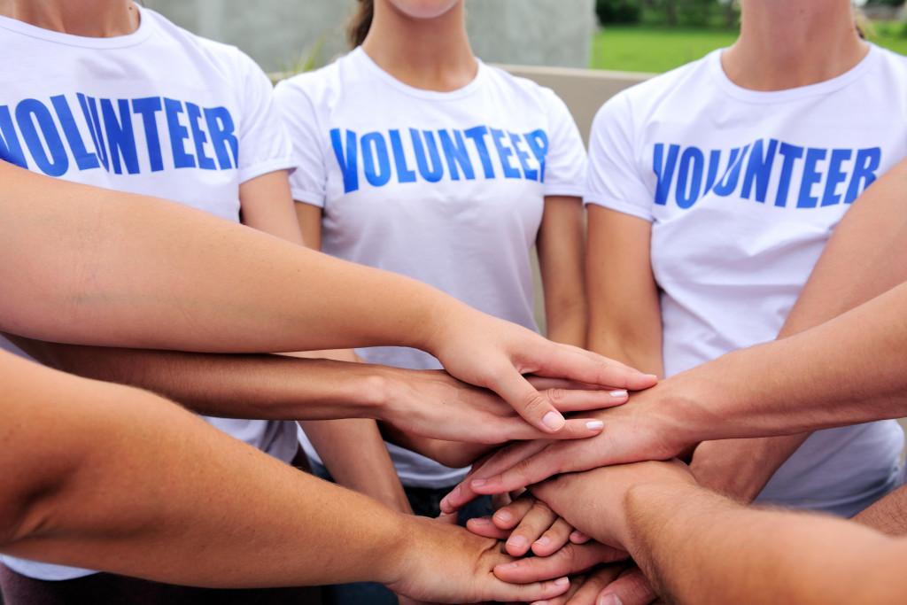 People wearing Volunteer shirts with their hands together for a cheer