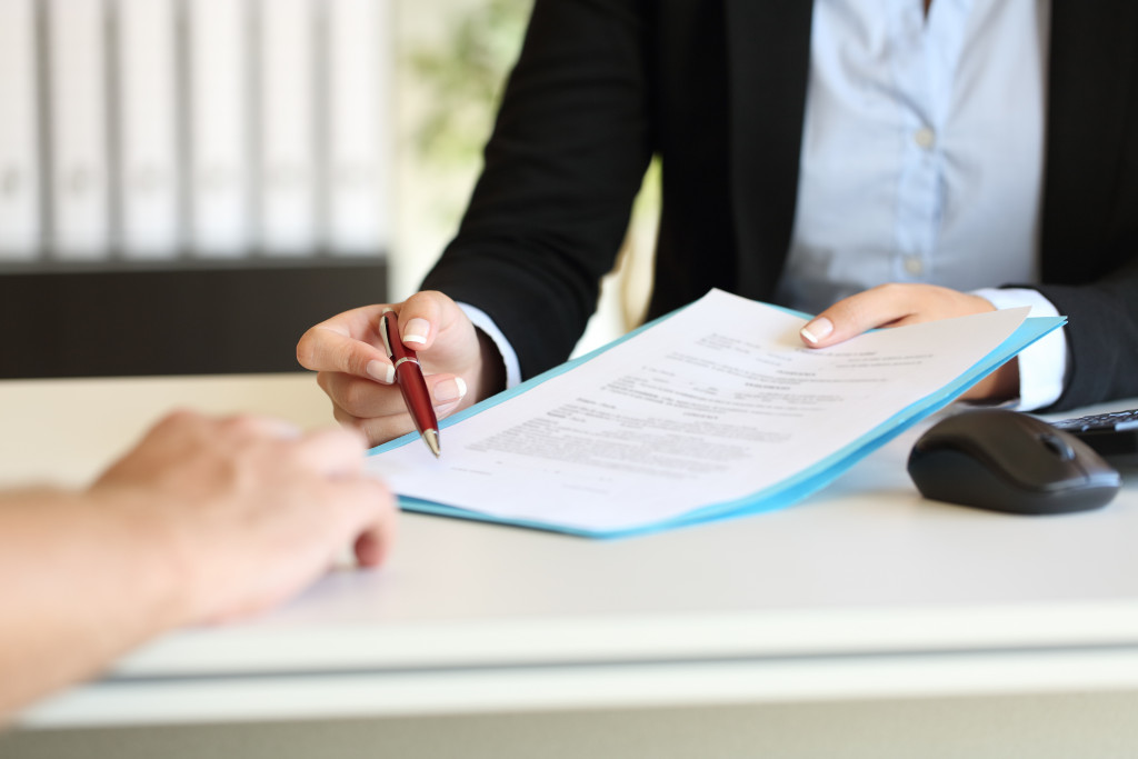 A businessman handing a document and pen to a person